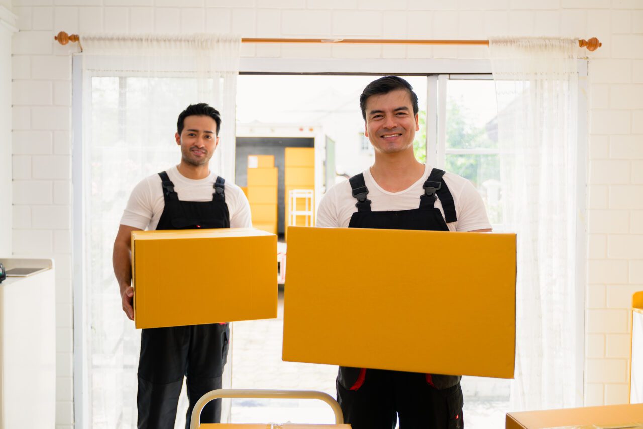 happy two delivery men holding parcel boxes to customer delivery men checking order of moving e1696172084131